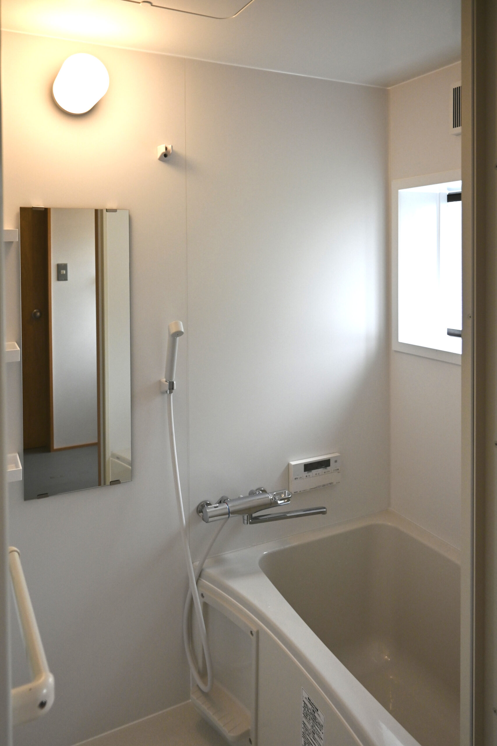 長屋リノベーションのユニットバス、シンプルでコンパクトなホワイトの浴室