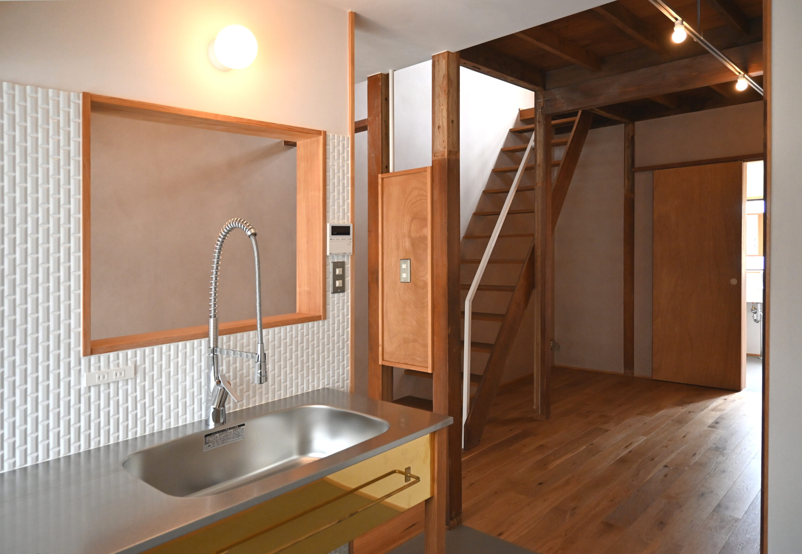 長屋リノベーションのキッチンダイニングスペース、シンプルなステンレス天板のオーダーメイド製作キッチン、シンプルでスタイリッシュな水栓