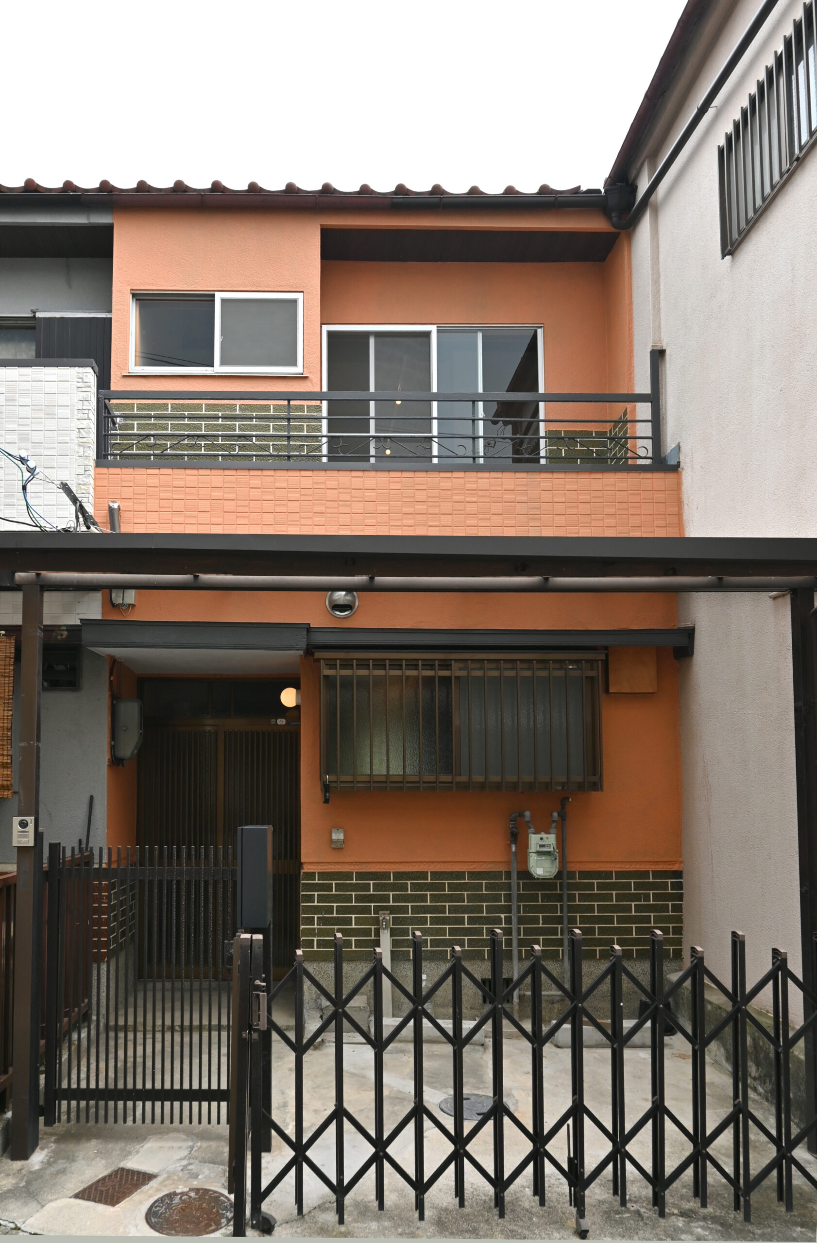 長屋リノベーションの外観、オレンジの塗装を施した日本家屋のリノベーション